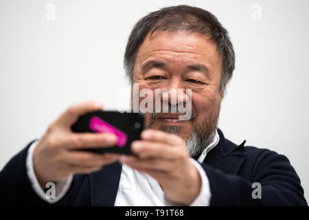 Düsseldorf, Deutschland. 16. Mai, 2019. Ai Weiwei, der chinesische Künstler, präsentiert seine Ausstellung in der Kunstsammlung Nordrhein-Westfalen auf einer Pressekonferenz und nimmt Fotos mit seinem Handy. "Alles ist Kunst. Alles ist Politik" ist, wie Ai kennzeichnet seine Arbeitsweise. Dies ist auch das Leitmotiv der seine größte Ausstellung in Europa, die die Kunstsammlung zeigt vom 18. Mai bis zum 1. September 2019. Credit: Federico Gambarini/dpa/Alamy leben Nachrichten Stockfoto