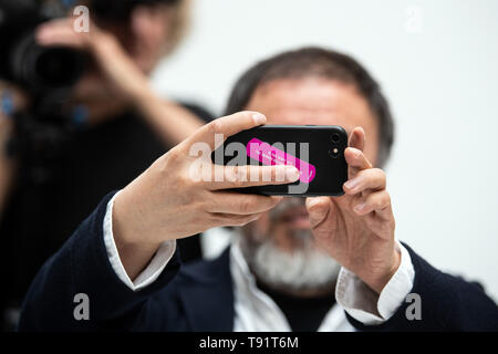 Düsseldorf, Deutschland. 16. Mai, 2019. Ai Weiwei, der chinesische Künstler, präsentiert seine Ausstellung in der Kunstsammlung Nordrhein-Westfalen auf einer Pressekonferenz und nimmt Fotos mit seinem Handy. "Alles ist Kunst. Alles ist Politik" ist, wie Ai kennzeichnet seine Arbeitsweise. Dies ist auch das Leitmotiv der seine größte Ausstellung in Europa, die die Kunstsammlung zeigt vom 18. Mai bis zum 1. September 2019. Credit: Federico Gambarini/dpa/Alamy leben Nachrichten Stockfoto