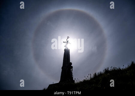 Aberystwyth Wales UK, Donnerstag, den 16. Mai 2019 Deutschland Wetter: eine perfekte Runde sun Halo, gebildet, wie die Strahlen der Sonne durch Eiskristalle in der oberen Atmosphäre, am Himmel über der Silhouette des War Memorial Aberystwyth. Die Halos, immer auf 22º von der Sonne, häufig darauf hin, dass Regen wird innerhalb der nächsten 24 Stunden fallen, da die cirrostratus Wolken, die sie verursachen, kann ein sich näherndes Frontschutzsystem bedeuten. Das Wetter wird eingestellt über Nacht aus dem feinen warmen Bedingungen zum kühler und feuchter Tage, eher typisch für Mitte Mai. Photo credit Keith Morris/Alamy Leben Nachrichten zu ändern. Stockfoto