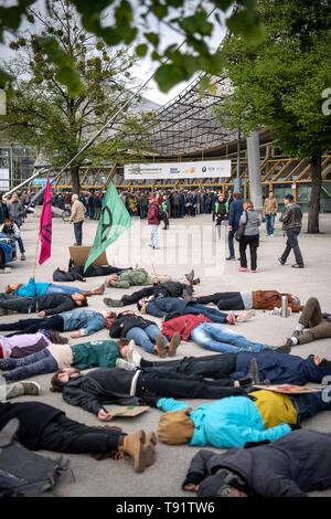 München, Deutschland. 16. Mai, 2019. Aktivisten der "Aussterben Rebellion der Münchner Gruppe liegen vor der Olympic Hall, wo die BMW-Hauptversammlung wird gehalten. Mit der Aktion die Teilnehmer gegen die Zerstörung des Planeten durch die Automobilhersteller zu protestieren wollen. Credit: Sina Schuldt/dpa/Alamy leben Nachrichten Stockfoto