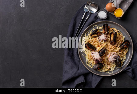 Mediterran Pasta mit Tintenfisch, Muscheln und Tomaten souse in der Platte. Freier Platz für Text, Hintergrund für Banner Stockfoto