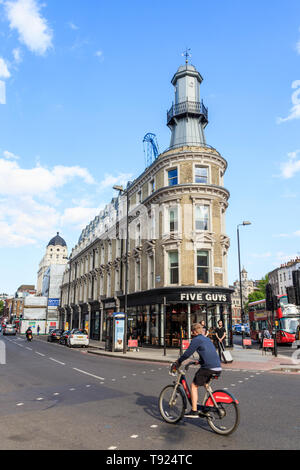 Ein Radfahrer auf einem Santander bike übergibt den Leuchtturm, ursprünglich eine Oyster Bar, jetzt ein fünf Jungs Burger Restaurant, King's Cross, London, UK, 2019 Stockfoto