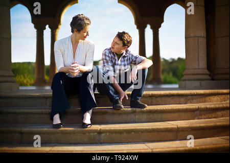 Mutter und Sohn sitzt auf den Stufen von einem opulenten Rotunde. Stockfoto