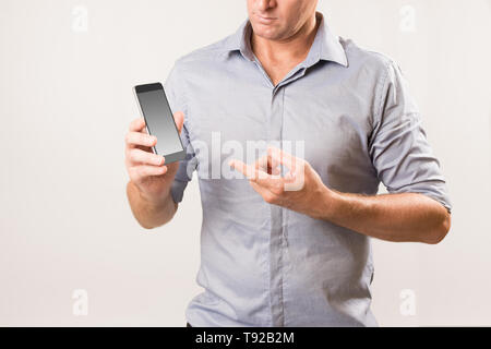 Mann mit Handy und zeigt auf den Bildschirm mit der anderen Hand - Modernes Leben / Telekommunikation Konzept Bild. Stockfoto