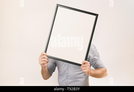 Unbekannter Mann mit Business Hemd Holding leeren Bilderrahmen vor seinem Gesicht - Geschäfte Konzept Bild wih kopieren Platz für Text. Stockfoto