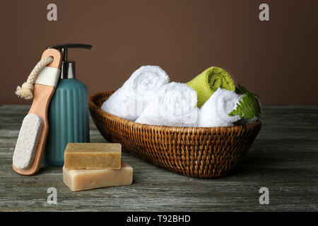 Weidenkorb mit gewalzten weiche Handtücher und Zubehör auf hölzernen Tisch Stockfoto