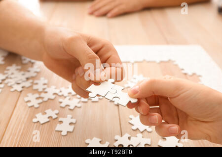 Junge Menschen Montage Puzzle auf hölzernen Tisch Stockfoto