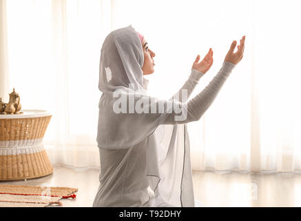 Junge muslimische Frau zu Hause beten Stockfoto