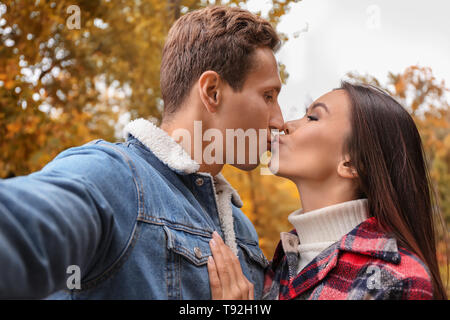 Glücklich liebend Paar unter selfie im Herbst Park Stockfoto