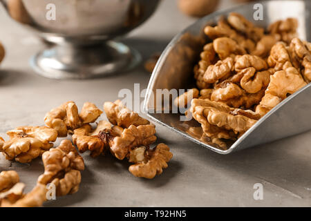 Schaufel mit schmackhaften Walnüsse auf grau Tabelle Stockfoto