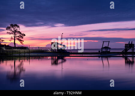 Dämmerung an einem Park mit Wasser Aktivitäten in Minnesott Beach, North Carolina. Schöne Reflexionen in den Teich durch die Neuse River Estuary. Stockfoto