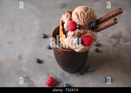 Waffel Kegel mit leckeren Eis in der Schale auf Graue Tabelle Stockfoto