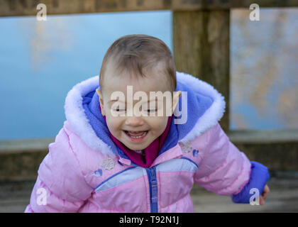 20 Monate altes Baby genießt das schöne Wetter. Für die kalten gebündelt. 1,5 Jahre altes Kleinkind wandern in Parks, wenn die Sonne scheint. Stockfoto