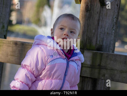 20 Monate altes Baby genießt das schöne Wetter. Für die kalten gebündelt. 1,5 Jahre altes Kleinkind wandern in Parks, wenn die Sonne scheint. Stockfoto