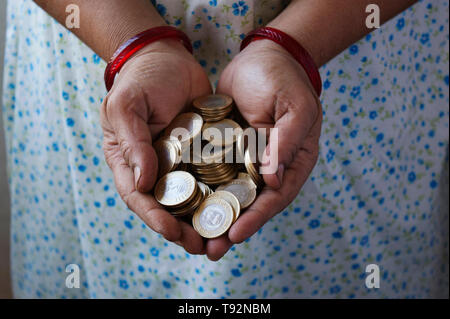 Hände halten 10 rupee Münzen. Stockfoto