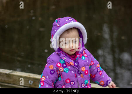 20 Monate altes Baby genießt das schöne Wetter. Für die kalten gebündelt. 1,5 Jahre altes Kleinkind wandern in Parks, wenn die Sonne scheint. Stockfoto