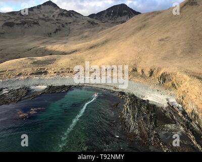 Ein Coast Guard Air Station Kodiak MH-65 Dolphin helicopter Aircrew findet eine Rettungsinsel mit vier Überlebenden, die Schiff aufgegeben, nachdem ihr Schiff einen Felsen schlug und begann auf dem Wasser südlich von Atka Island, Alaska, 11. Mai 2019. Das bordpersonal die Überlebenden, die Performativität von überleben Anzüge und kletterte in eine Rettungsinsel befindet, und nachdem Sie am Ufer der Hubschrauber Crew in der Nähe von Ihnen landete und transportiert sie zu er Klinik, wo Sie medizinisch bewertet wurden. Foto mit freundlicher Genehmigung der US-Küstenwache. Stockfoto