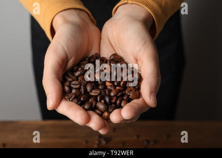 Frau mit Handvoll Kaffeebohnen, Nahaufnahme Stockfoto