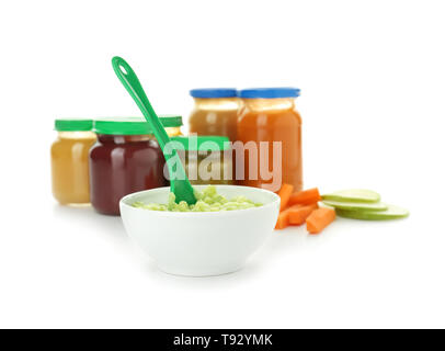 Schüssel gesunde Gemüse pürieren und Gläschen mit Babynahrung auf weißem Hintergrund Stockfoto