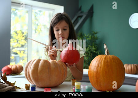 Süße kleine Mädchen Zubereitung Kürbis für Halloween zu Hause Stockfoto