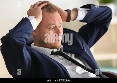 Mann in Panik am Arbeitsplatz im Büro Stockfoto
