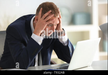 Mann in Panik am Arbeitsplatz im Büro Stockfoto