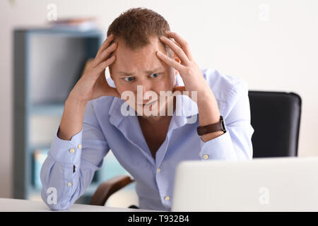 Mann in Panik am Arbeitsplatz im Büro Stockfoto