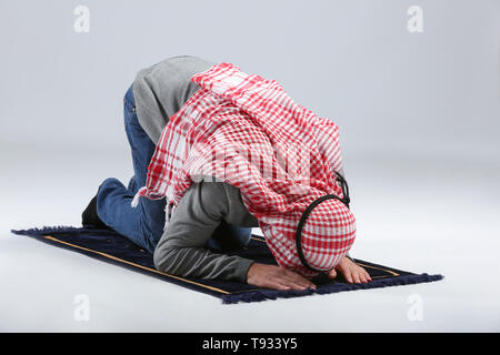 Jungen muslimischen Mann, der betet auf hellen Hintergrund Stockfoto