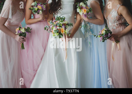 Braut und Brautjungfern. Schöne junge Frauen in Kleidern und mit sträuße von frischen Blumen. Stockfoto