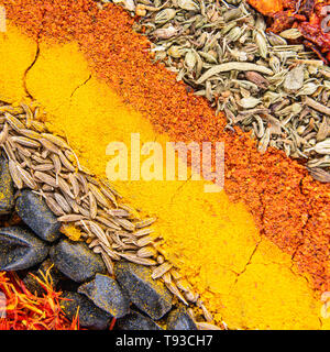 In der Nähe von Gewürzen für östliche Gericht Pilav eingestellt. Diagonale würzige Streifen enthält satureja, Kurkuma, cuminum, Berberitze, Paprika und Tagetes. Anzeigen von ab Stockfoto
