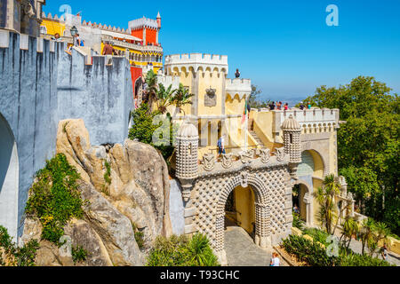 Touristen, die zu Pena National Palace - UNESCO-Weltkulturerbe. Blick auf den Türmen, Türmchen und Terrassen. Sintra, Portugal Stockfoto