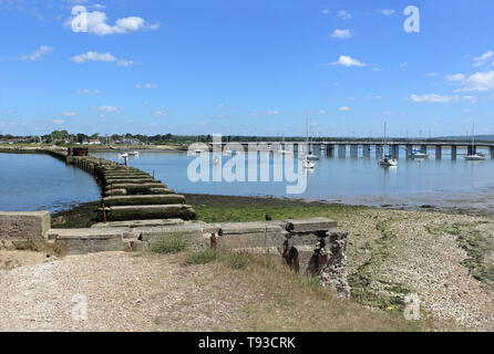 Langstone Hafen, Hampshire, England. Die Überreste von Hayling Billy mit Langstone Brücke in der Ferne. Stockfoto