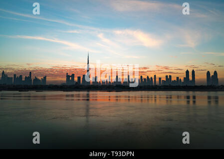 Morgen oder Sonnenaufgang, Dämmerung in Dubai. Schöne farbige wolkiger Himmel über der Innenstadt von Dubai. Lichtschein über Wolkenkratzer. Stockfoto