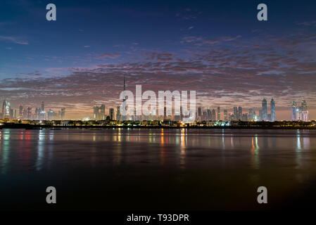 Morgen oder Sonnenaufgang, Dämmerung in Dubai. Schöne farbige wolkiger Himmel über der Innenstadt von Dubai. Lichtschein über Wolkenkratzer. Stockfoto