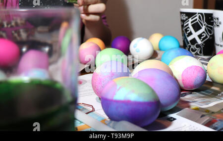 Ein junges Mädchen arbeitet auf dem Sterben Ostereier am Küchentisch in Ihrer Küche. Stockfoto