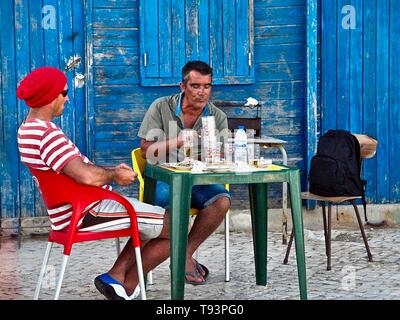 Fischer essen vor Blau fisher Haus oder Hütte in Olhos de Agua an der Algarve in Portugal Stockfoto