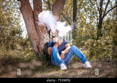 Stattliche vaper genießen ein elektronisches Rauchen Gerät. Moderne Möglichkeiten des Verlassens des Tabaks. Stockfoto