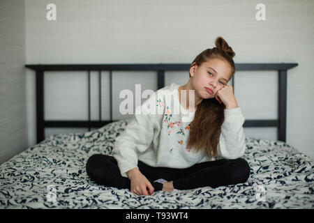 Zwölf Jahre alten süße Mädchen Spaß in Ihrem Zimmer auf dem Bett zu sitzen. Stockfoto