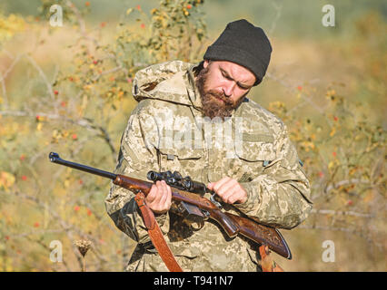 Mann Jäger mit Gewehr Pistole. Boot Camp. Uniform Mode. Bärtiger Mann Jäger. Die Streitkräfte. Camouflage. Jagd Fähigkeiten und Waffen Ausrüstung. Wie schalten Sie die Jagd in Hobby. Bitte keine Stockfoto