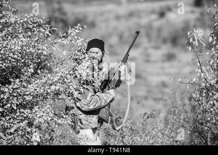 Bärtiger Mann Jäger. Uniform Mode. Die Streitkräfte. Camouflage. Jagd Fähigkeiten und Waffen Ausrüstung. Wie schalten Sie die Jagd in Hobby. Mann Jäger mit Gewehr Pistole. Schießen gerade und sehen toll aus. Stockfoto