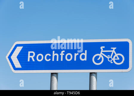 Blaues Schild mit dem Radweg nach Rochford, Essex, Großbritannien. Blaues Schild, weiße Pfeile. Straßenverkehrsordnung empfohlene Route für Pedalzyklen Stockfoto