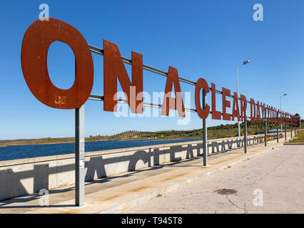 Große rote rusty Großbuchstaben AN EINEM KLAREN TAG KÖNNEN SIE FÜR IMMER blauer Himmel, Alqueva Dam, Moura, Portugal Stockfoto