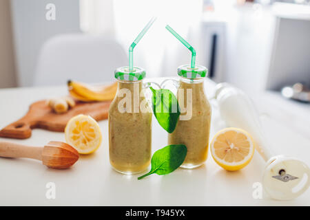 Flaschen mit Spinat und Bananen Smoothie mit Zutaten aus der Küche. Gesunde Detox-diät Stockfoto