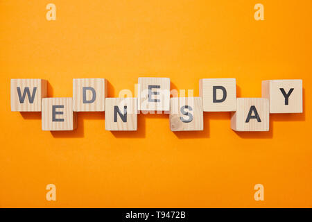 Blick von oben auf die Holzblöcke mit Buchstaben auf orange Oberfläche Stockfoto