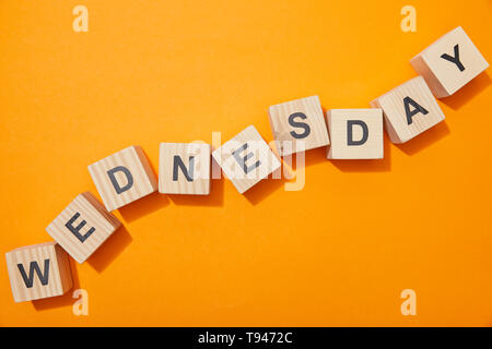 Blick von oben auf die Holzblöcke mit Buchstaben auf orange Oberfläche Stockfoto