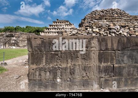 Geschnitzte relief Tafeln an den Wänden des Südens Ballcourt mit der Pyramide der Nischen hinter an der Präkolumbianischen archäologischen Komplex von El Tajin in Tajin, Veracruz, Mexiko. El Tajín von 600 bis 1200 CE und während dieser Zeit zahlreiche Tempel, Paläste, ballcourts blühte, und die Pyramiden wurden von der Totonac Menschen erbaut und ist eines der größten und wichtigsten Städte der klassischen Ära der Mesoamerika. Stockfoto