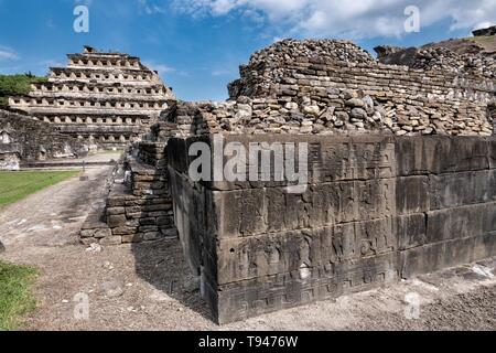 Geschnitzte relief Tafeln an den Wänden des Südens Ballcourt mit der Pyramide der Nischen auf der linken Seite an der Präkolumbianischen archäologischen Komplex von El Tajin in Tajin, Veracruz, Mexiko. El Tajín von 600 bis 1200 CE und während dieser Zeit zahlreiche Tempel, Paläste, ballcourts blühte, und die Pyramiden wurden von der Totonac Menschen erbaut und ist eines der größten und wichtigsten Städte der klassischen Ära der Mesoamerika. Stockfoto