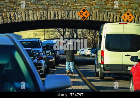 Obdachloser wandern in zwischen Autos um Spenden bitten Stockfoto