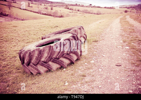 Paar Reifen eines großen Traktor zerlegt und in einem italienischen Land road-getonten Bild Stockfoto