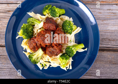 Süße und pikante Fleischbällchen Mahlzeit über Pasta mit Brokkoli Stockfoto